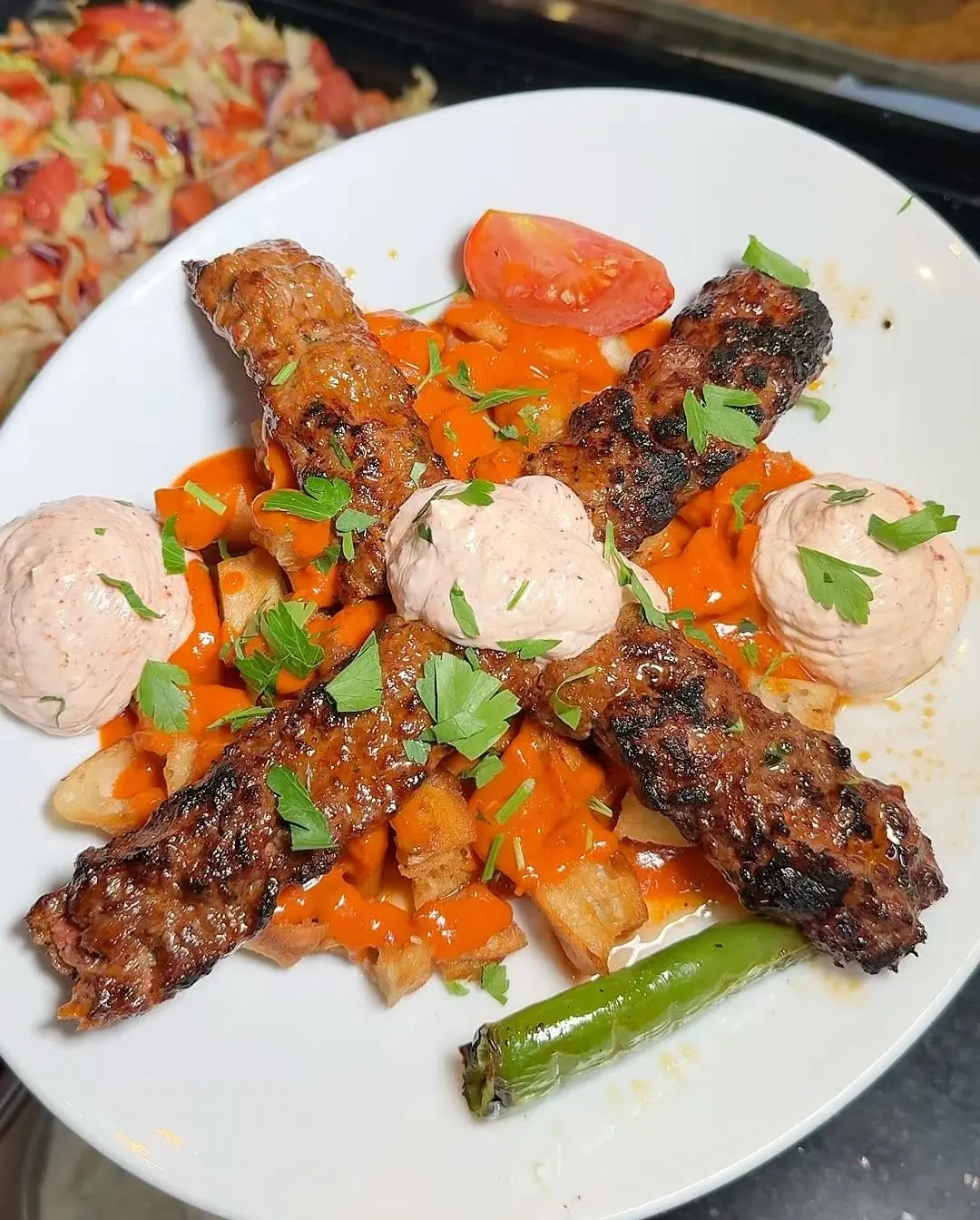 Adana au yaourt, sauce épicée et piments grillés